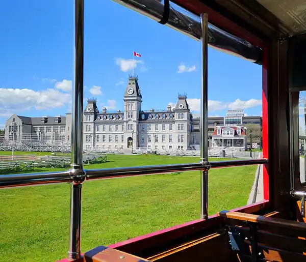 View from inside a classic red trolley of RMC the Royal Military College, a large limestone building in Kingston Ontario.