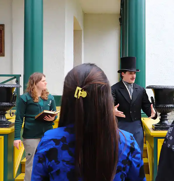 Man dressed up in 1800's attire delivering a guided tour at Bellevue house in Kingston, Ontario.