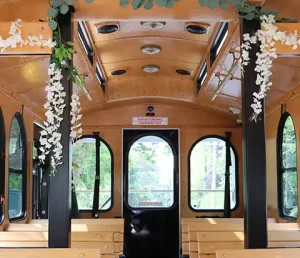 View from inside the white wedding trolley from Kingston Trolley Tours. Beautifully adorned with solid wood benches and wisteria flower decorations.